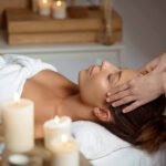 young woman having face massage relaxing spa salon