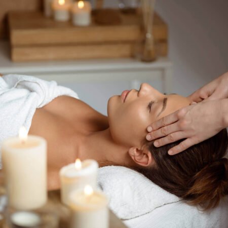 young woman having face massage relaxing spa salon
